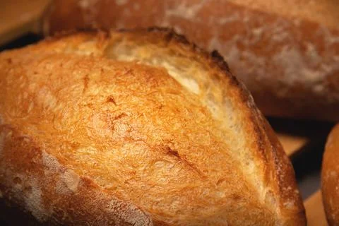 Appetizing fresh hot artisan bread. Close-up of a loaf of delicious bread on a Stock Photos
