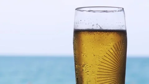 Appetizing glass of cold beer on beach. drops of water roll down a glass Stock Footage 94420267