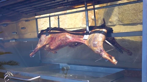 Appetizing grilled lamb on the spit, roasted meat rotates Stock Footage 128917009