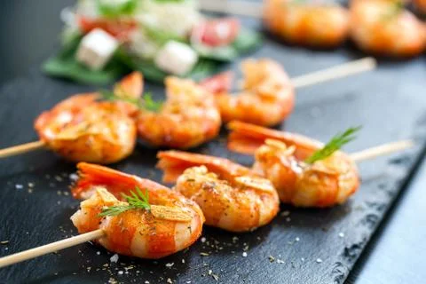 Appetizing grilled prawns on skewer. Stock Photos