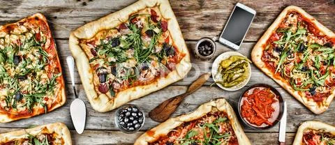 Appetizing homemade pizza on a wooden table. Friendly feast at home. Stock Photos