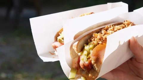 Appetizing hot dogs in hand. Close-up Stock Footage 279681945