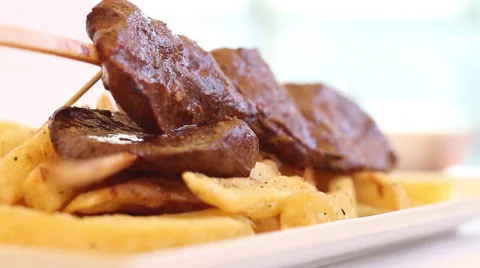 Appetizing hot heart beef peruvian dish called "anticucho" with fries. Stock Footage 68103184