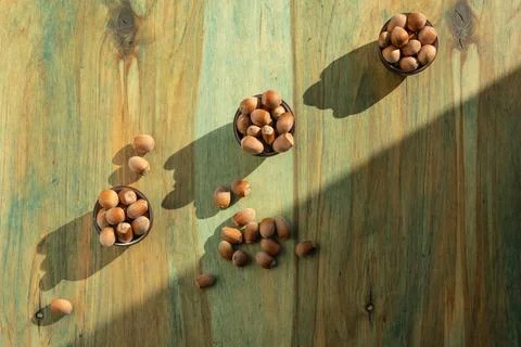 Appetizing inshell hazelnuts in three small ceramic bowls and some scattere.. Stock Photos