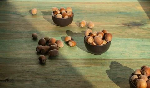 Appetizing inshell hazelnuts in three small ceramic bowls and some scattere.. Stock Photos