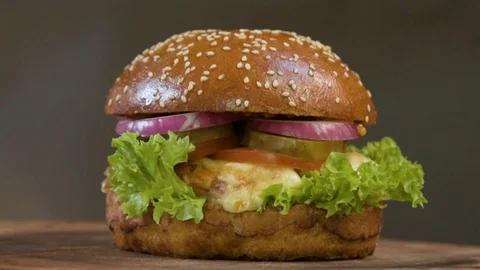 Appetizing juicy burger with onion, cheese, tomato, beef cutlet on a salad leaf Stock Footage 90488337