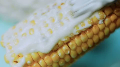 Appetizing kitchen study: spreading white topping across grilled kernels Foto stock