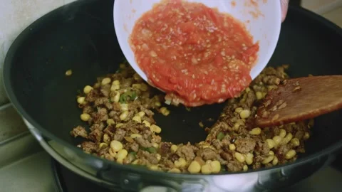 Appetizing kitchen view of pouring crushed tomato salsa into the skillet Stock Footage 342152882