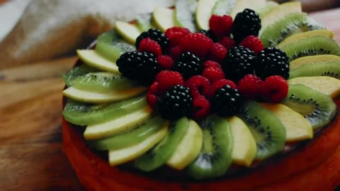 Appetizing kiwi slices arranged around a golden cheesecake in macro, 4K Stock Footage 341116155