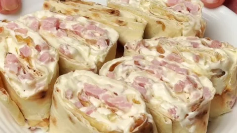 Appetizing lavash rolls with smoked ham and cream sauce served on a white plate Stock Footage 325032591