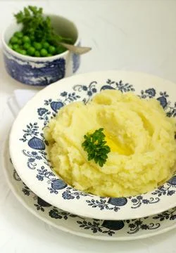 Appetizing mashed potatoes with butter and parsley. Rustic style. Stock Photos