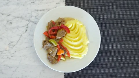 Appetizing mashed potatoes with pieces of stew and vegetables. White spinning Stock-Footage 120107023