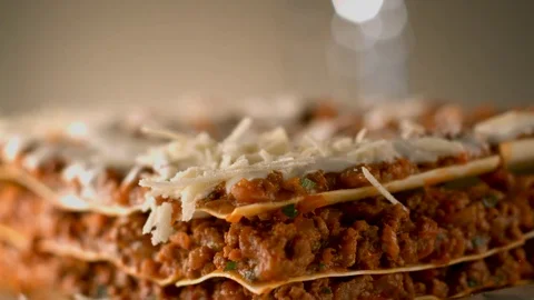 Appetizing meat lasagna is sprinkled with pieces of grated cheese. Stock Footage 83724110