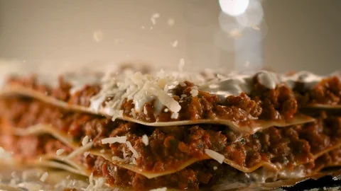 Appetizing meat lasagna is sprinkled with pieces of grated cheese. Stock Footage 83724255