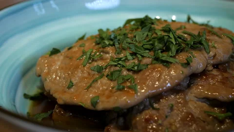 Appetizing meat steak covered with sauce and parsley rotates in the blue bowl Video stock 132414191