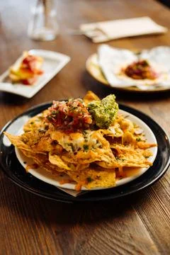 Appetizing nacho dish topped with vegetable sauces Stock Photos