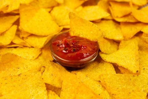 Appetizing nachos chips on a white plate and a spicy sauce close-up. Stock Photos