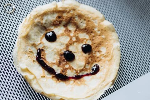Appetizing pancake with jam in the shape of a smile Stock Photos