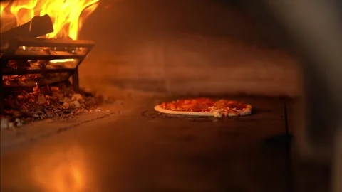 Appetizing pizza baking in a hot burning oven Stock Footage 240312693