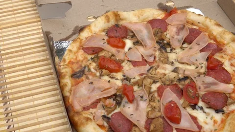 Appetizing pizza with different meats, cheese, ketchup and tomato in a paper box Stock Footage 89004161
