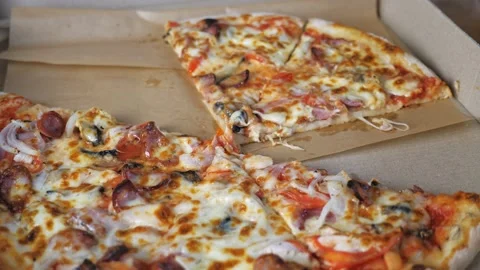Appetizing pizza lies in a box, a few pieces of pizza are missing. The opened Stock Footage 204037612