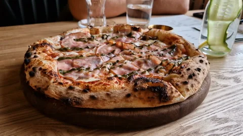 Appetizing pizza on a table in a cafe. Stock Footage 241214085