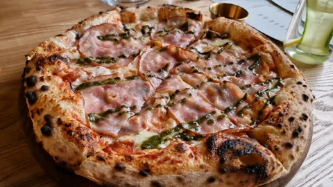 Appetizing pizza on a table in a cafe. Stock Footage 241215036