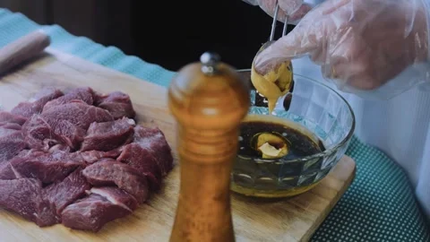 Appetizing plated dinner: stirring marinade around fresh steak cubes Stock Footage 342181247