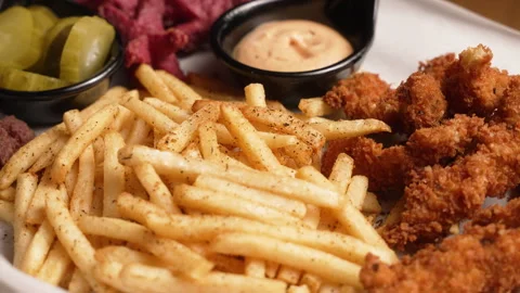 Appetizing platter of fast food with fried chicken, french fries, sausages Stock Footage 338389424