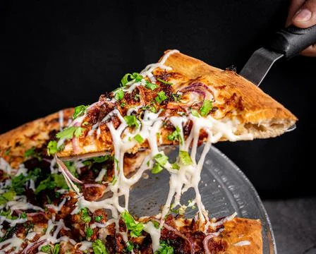 Appetizing pressed crackling pizza, on a base. Stock Photos