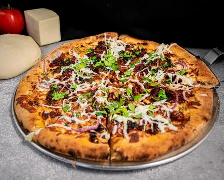 Appetizing pressed crackling pizza, on a base. Stock Photos
