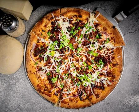 Appetizing pressed crackling pizza, on a base. Stock Photos