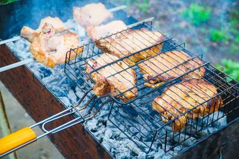 Appetizing raw meat kebab is cooked on the grill on the wood, in the open air Stock Photos