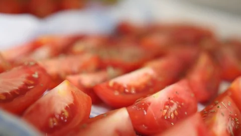 Appetizing red sliced tomatoes sprinkled with spices. Concept of eating and Stock Footage 106975322