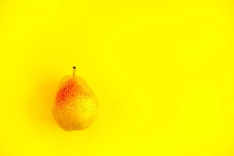 Appetizing ripe pear with red side on a yellow background. Foto stock