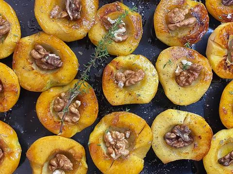 Appetizing roasted baked apples with walnuts and honey glaze on a baking tray 写真素材