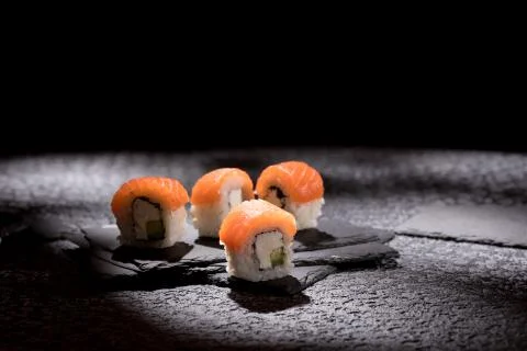 Appetizing rolls on a textured black background. Japanese food concept. Close Stock Photos