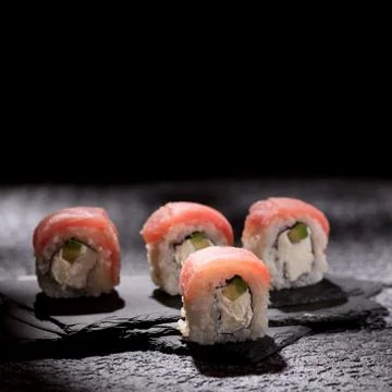 Appetizing rolls on a textured black background. Japanese food concept. Close Stock Photos