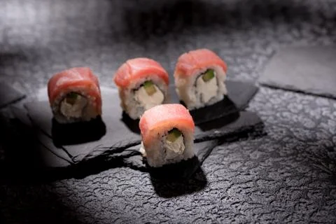 Appetizing rolls on a textured black background. Japanese food concept. Close Stock Photos