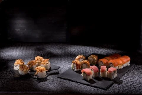 Appetizing rolls on a textured black background. Japanese food concept. Close Stock Photos