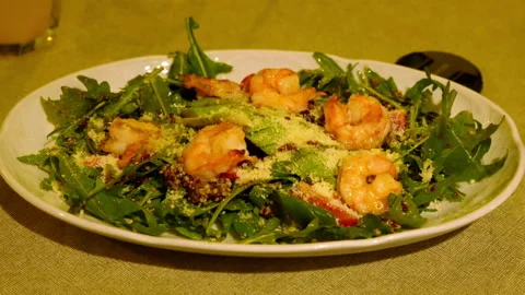 Appetizing salad of arugula, avocado and shrimp on a flat round plate Stock Footage 303472239