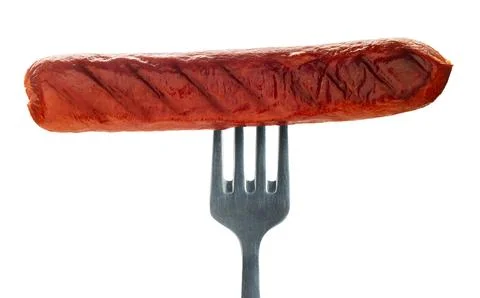 Appetizing sausage on a fork Stock Photos