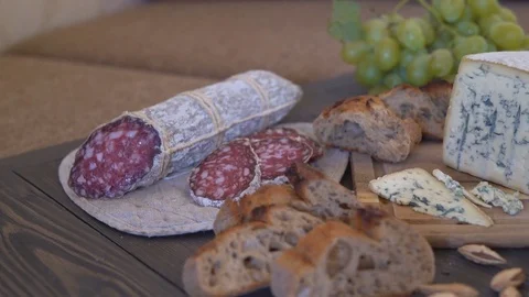Appetizing sausage loaf in a bag of marble fabric. the sausage rests on a wooden 스톡 동영상 81940327