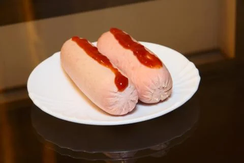 Appetizing sausage on white ceramic. Stock Photos