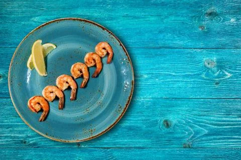 Appetizing shrimps on a blue plate Stock Photos