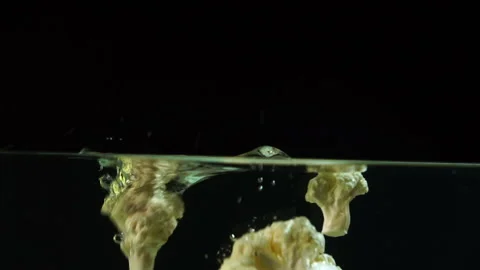 An appetizing slice of cauliflower beautifully falls into the water with bubbles Video stock 116018468