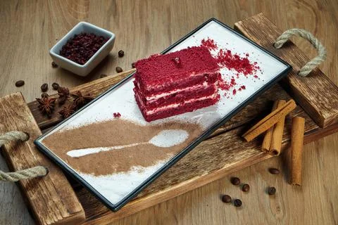 An appetizing slice of sponge cake with white cream and red shortcakes. Tasty Stock Photos