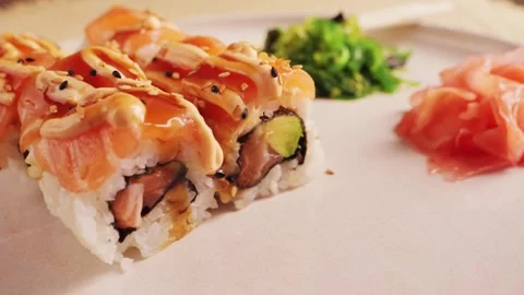 Appetizing sushi rolls with salmon, avocado with special sauce close-up on the Stock Footage 317321196