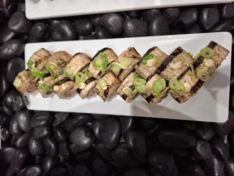 Appetizing Sushi Rolls Served on a White Plate with Creative Presentation Stock Photos