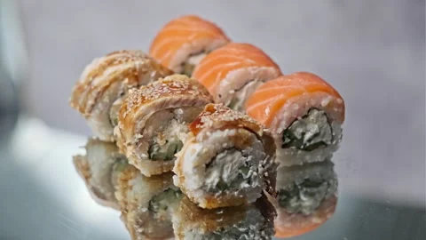 Appetizing Sushi Rotates on a Mirror Table Stock Footage 252576168